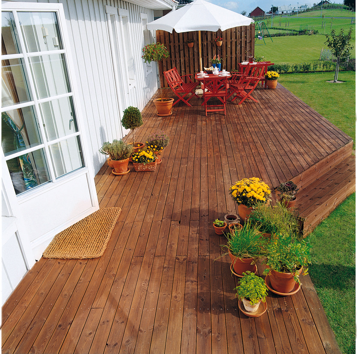 A wooden garden decking painted in brown Teknos Woodex Aqua Wood Oil
