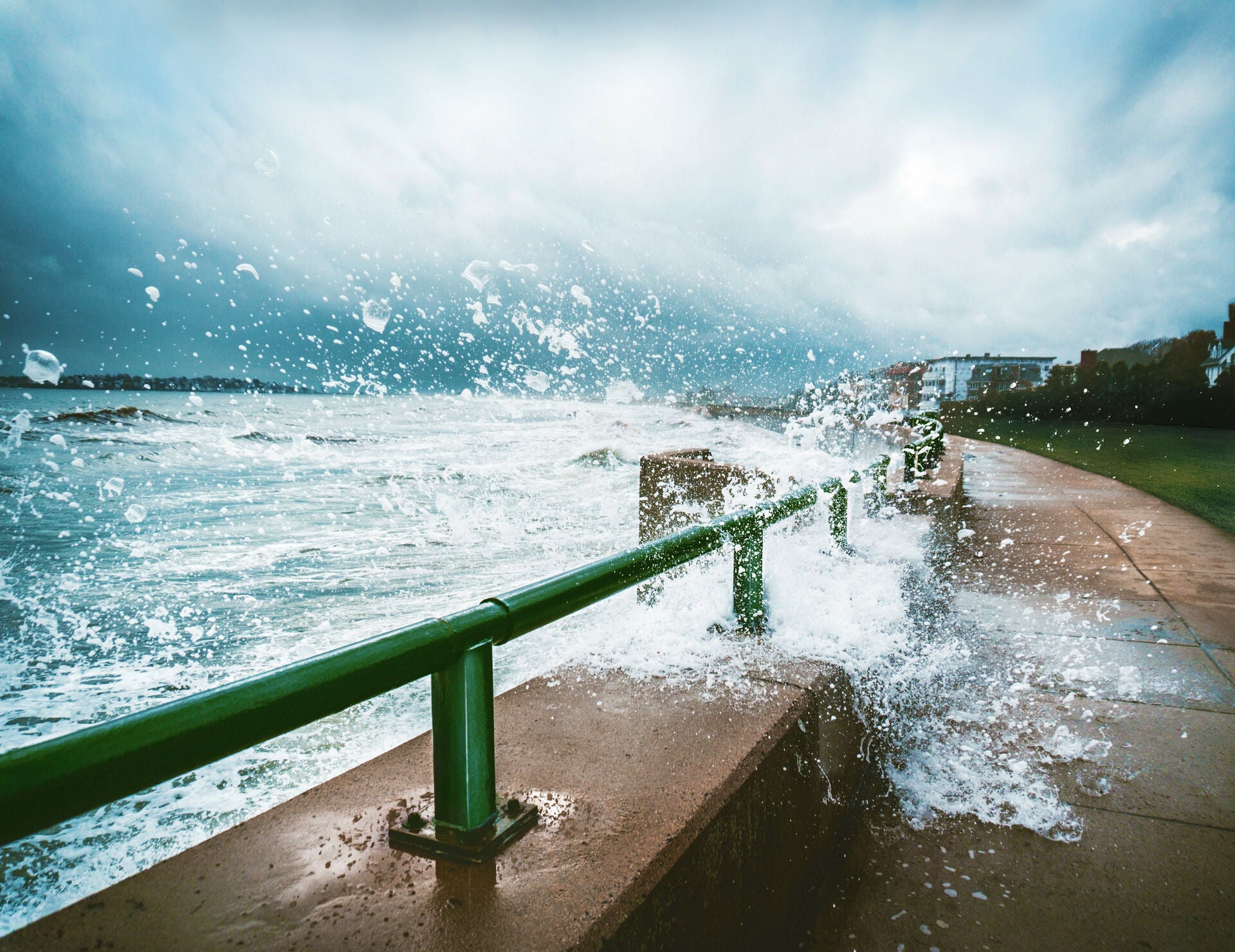 A metal rail on the coast painted in green Teknos Ferrex combi metal paint getting splashed by the ocean to demonstrate corrosion resistance.