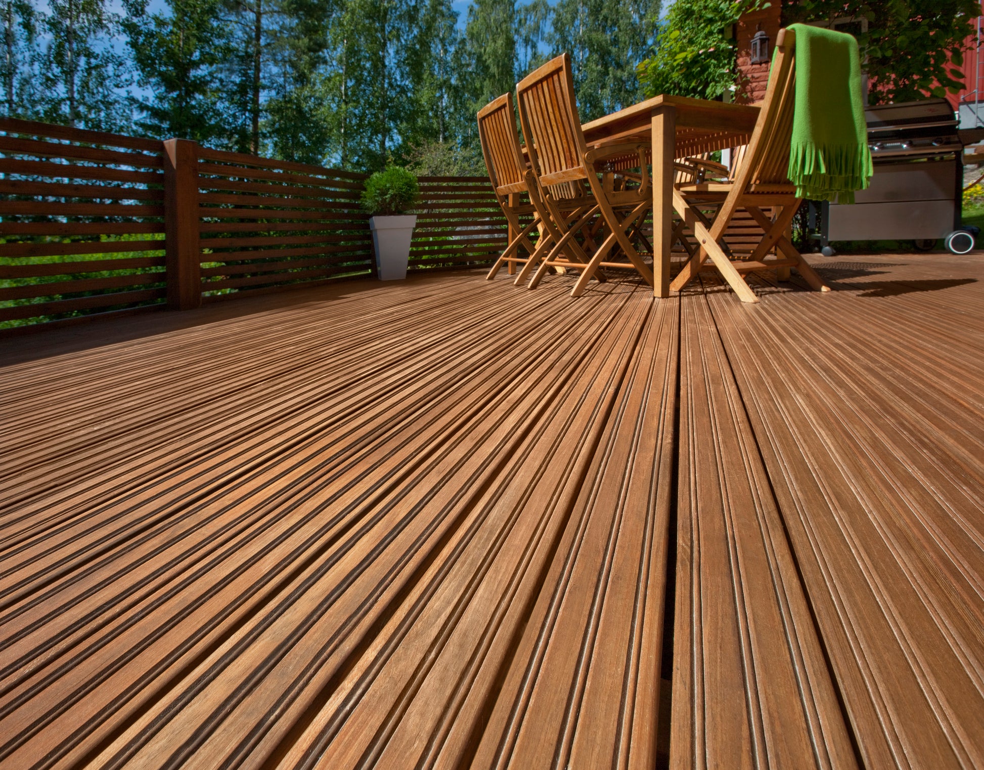 A wooden decking and slat fence painted with Teknos Woodex Wood Oil brown